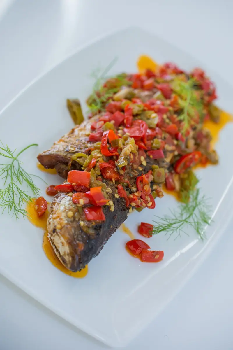 Oven-roasted sea bass topped with a bright red pepper and dill relish