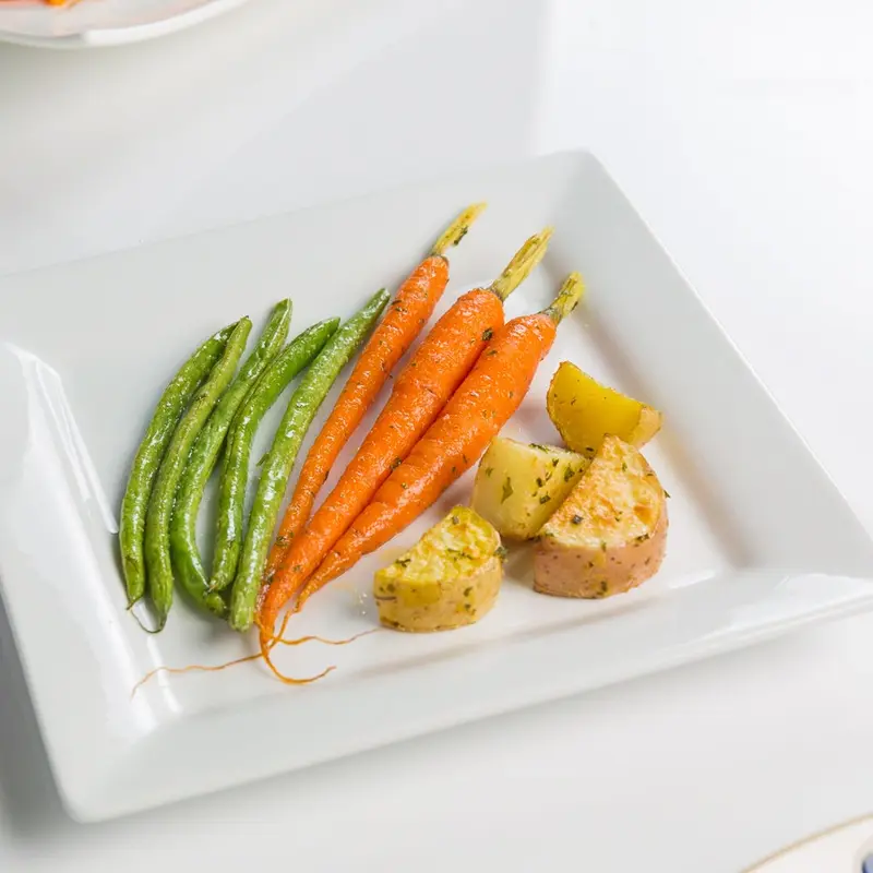 Green beans, carrots and roasted potatoes on a square plate